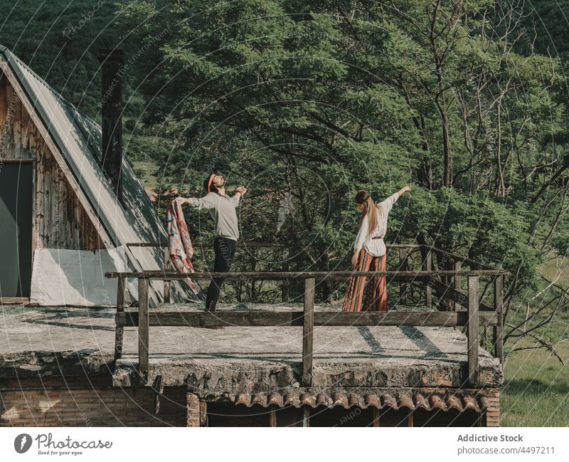 Hippie couple dancing near cabin hippie dance bonding nature countryside freedom leisure pastime boho recreation summer bohemian structure harmony active