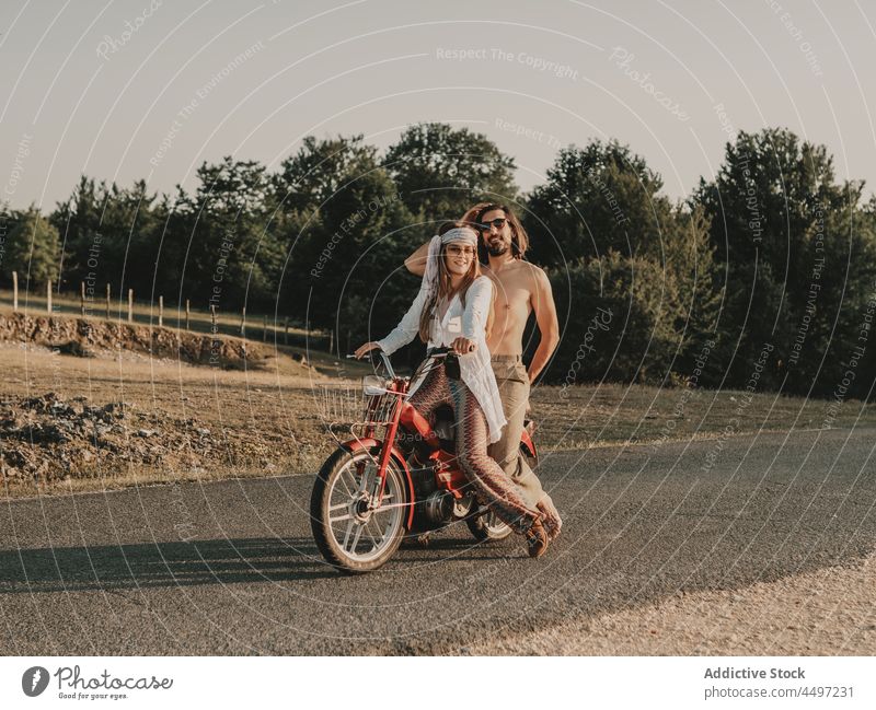 Hippie couple riding on moped relationship ride hippie nature journey trip freedom road countryside vehicle summer travel love boho bonding fondness roadway