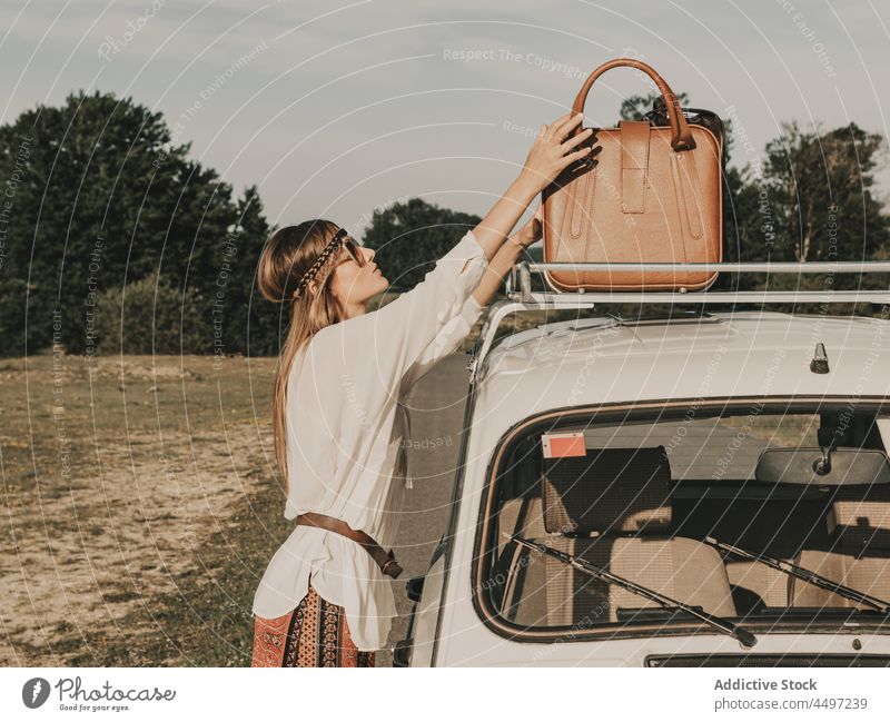 Hippie taking suitcase from retro car woman hippie luggage nature countryside old timer trip journey freedom leisure adventure pastime recreation summer style