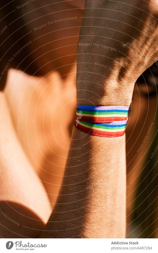 Person with rainbow ribbon on hand in summer time person fresh natural healthy tropical plant green São Tomé and Príncipe african organic lgbtq tolerance equal