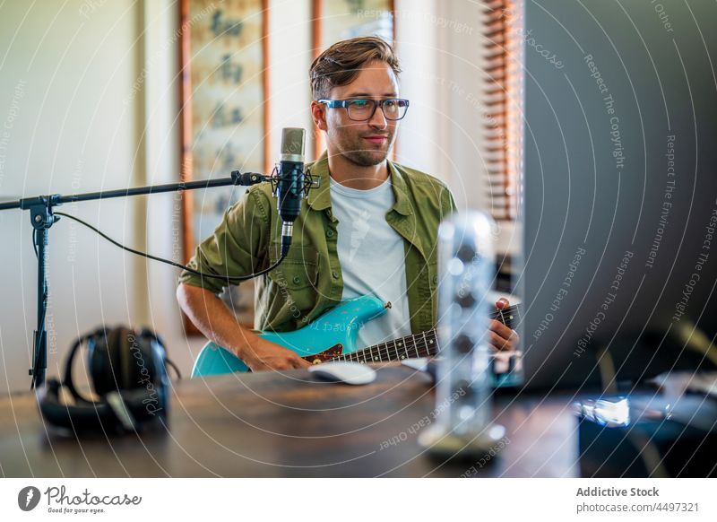 Guitarist playing electric guitar in studio man guitarist headphones microphone musician record instrument melody talent male hobby skill perform sound classic