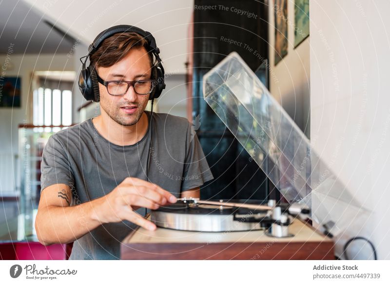 Guy in headphones listening to music from player man meloman sound melody record turntable eyeglasses song concentrate nostalgia vintage retro male