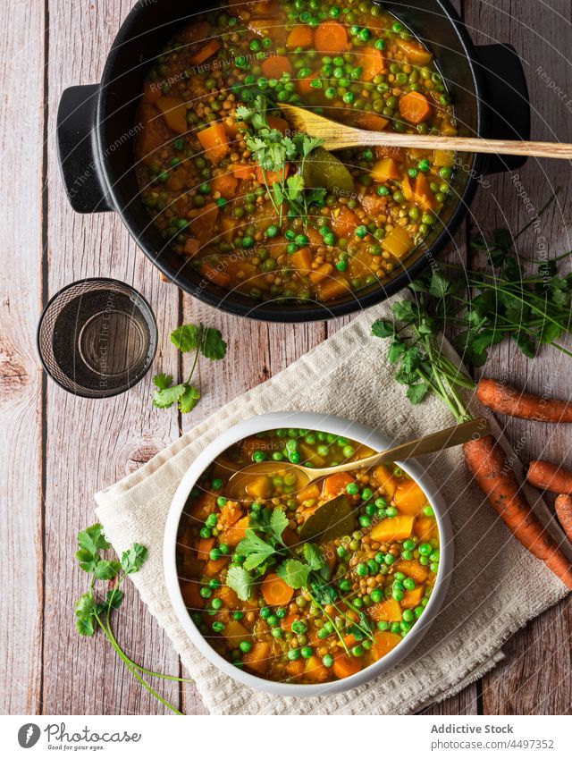 Curry with green peas and vegetables curry meal food basil cuisine healthy food dish carrot delicious organic portion serve bowl pot spoon wooden tasty