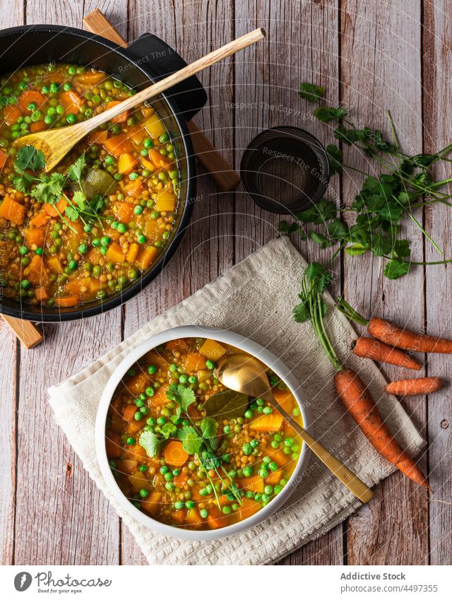 Curry with green peas and vegetables curry meal food basil cuisine healthy food dish carrot delicious organic portion serve bowl pot spoon wooden tasty