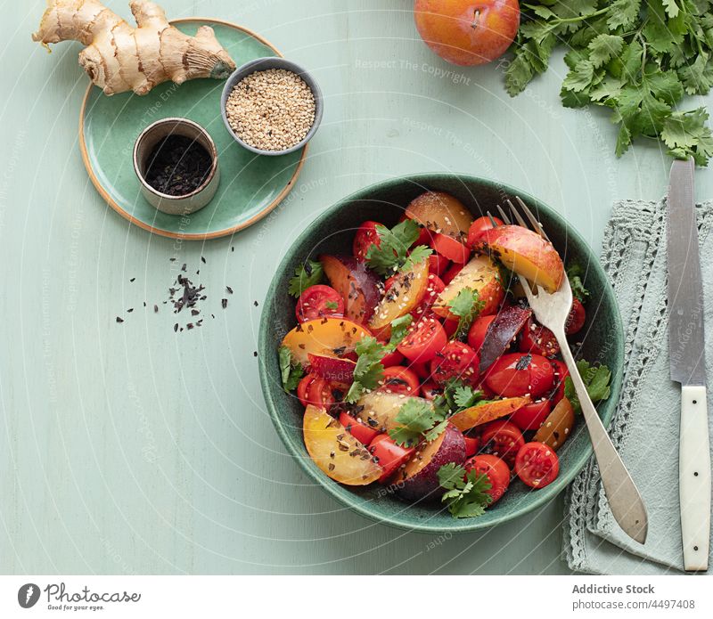 Tomato salad with fruit on the table tomato plate vegetarian colorful raw ingredients plum balsamic summer foods meal tomato salad lunch dish delicious plums