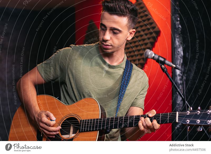 Musician playing guitar and singing in club man instrument musician microphone perform talent male young hobby instrumental audio melody artist sound smile