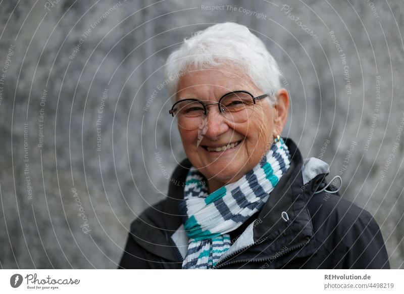 Portrait of a senior woman in front of concrete Upper body Gray-haired White-haired Authentic Adults fortunate Happy Contentment Smiling naturally