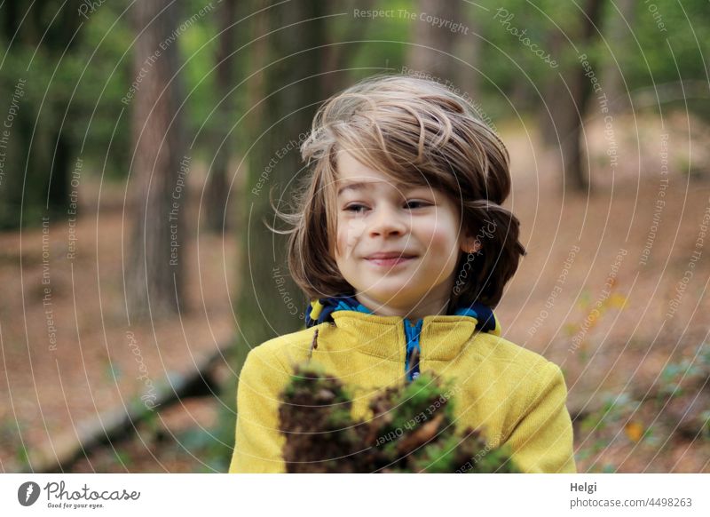 Kinderfreuden - Boy playing in the forest with natural materials Human being Boy (child) Child out Nature Forest Playing Joy fun portrait Moss game Infancy