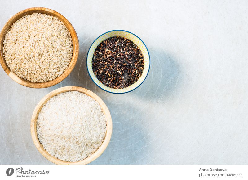 Different types of rice in wooden bowls such as basmati, brown a different white table various cereals black thai food healthy wild ingredient grain mix closeup
