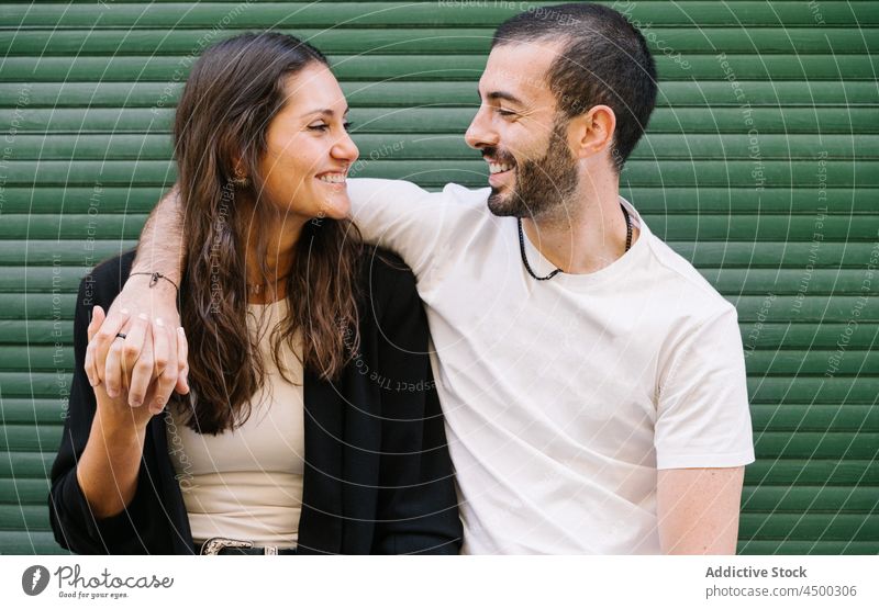 Joyful loving ethnic couple smiling and looking at each other on street laugh hug love cheerful relationship together romantic happy affection embrace date