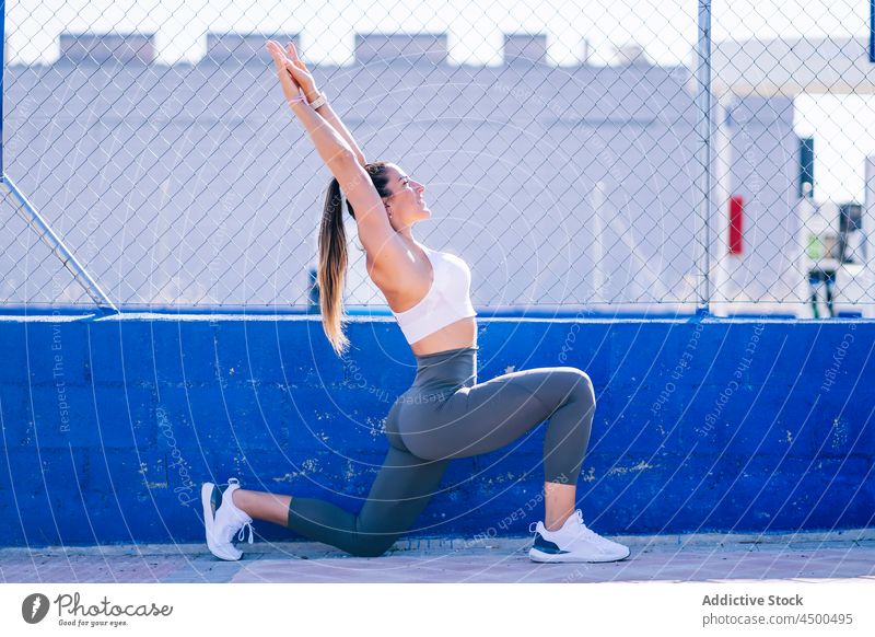 Fit woman doing lunges on sports ground exercise fit fitness training sporty slim sportswear activewear lifestyle workout female wellness wellbeing lady move