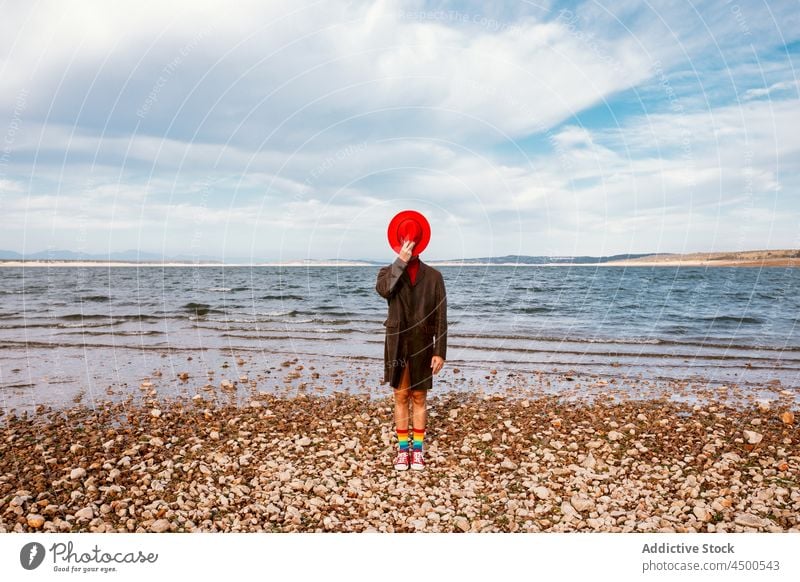 Person with hat standing on seacoast shore nature coat summer center style serene tranquil beach seaside coastline ocean horizon seashore waterfront landscape