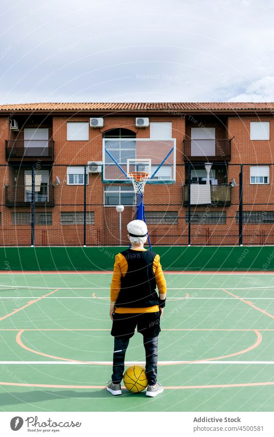 Unrecognizable sportsman with basketball on playground hoop sports ground game training court hobby professional summer public activity person challenge