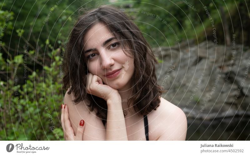 Dark haired woman in nature - portrait Spring out Nature Congenial nice kind Smiling Strand of hair Meditative Esthetic brown eyes Curl Lifestyle Elegant