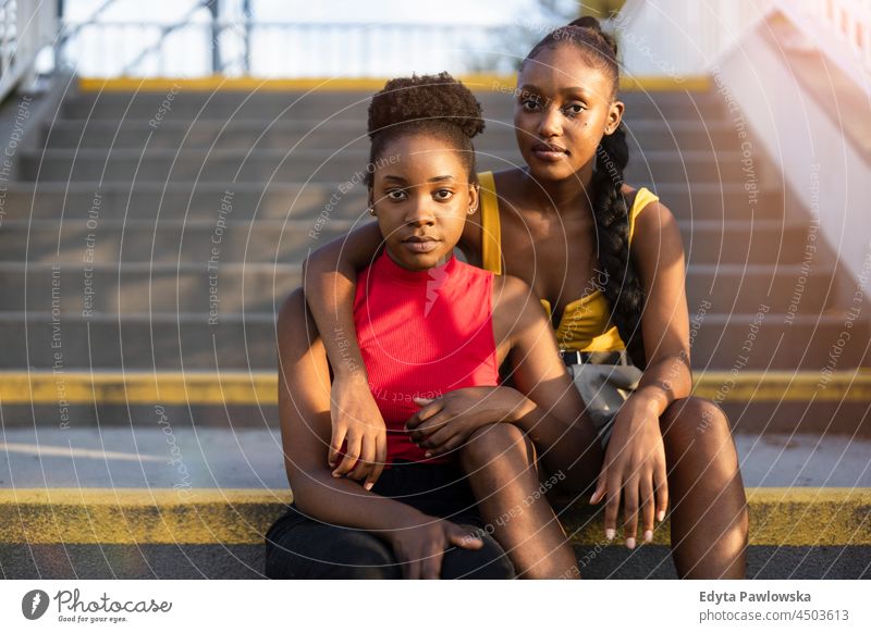 Portrait of two young female sitting on the stairs youth sisterhood attractive girlfriends real people millennials cool diversity black friendship together