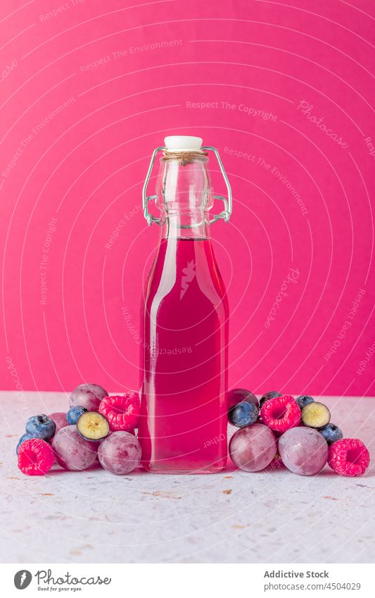 Bottle with fruit juice on table bottle berry sweet serve drink beverage refreshment vitamin glass delicious tasty healthy bowl appetizing assorted mix