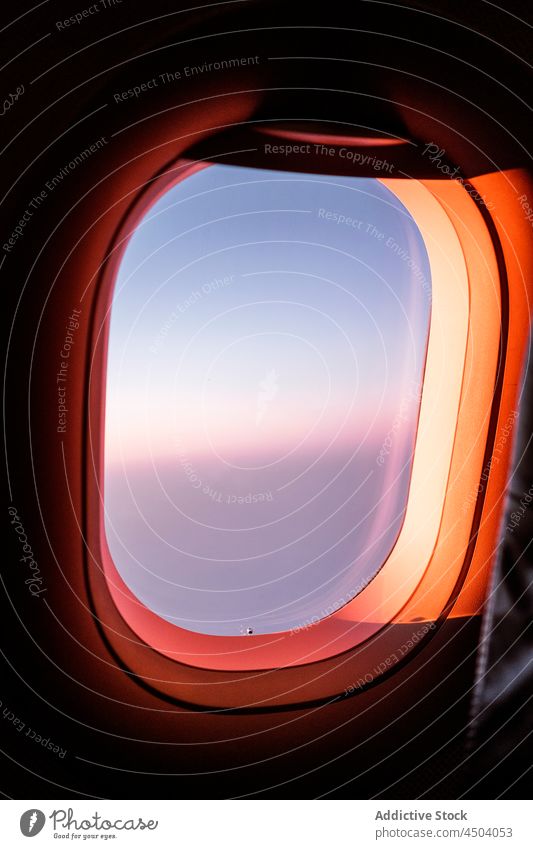 Aircraft flying over clouds through window aircraft sky wing sunset flight airplane travel aviation trip view transport journey altitude jet scenic high