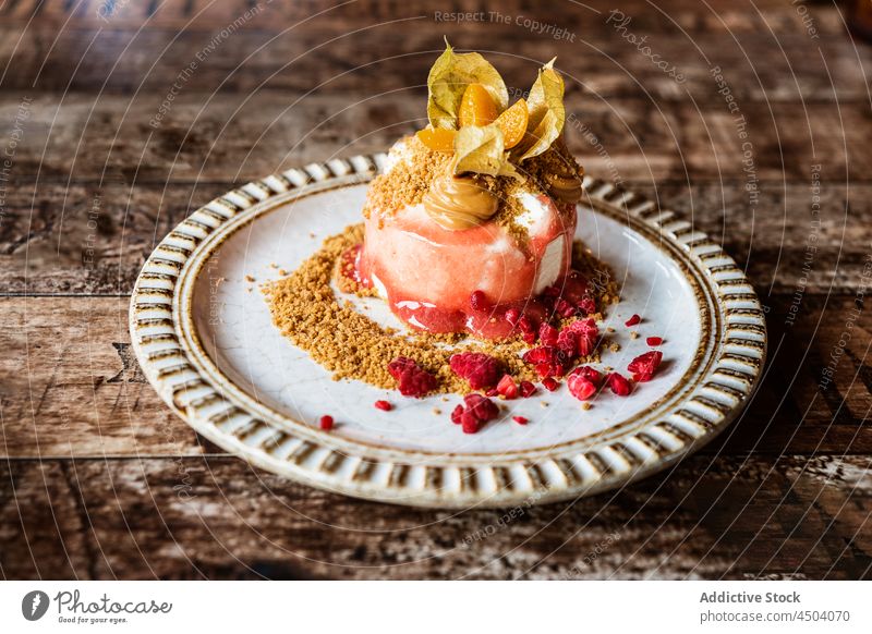 Delicious dessert with physalis on plate on wooden table berry food tasty cream sweet crumb serve delicious cookie cake appetizing decorate eat sugar dish