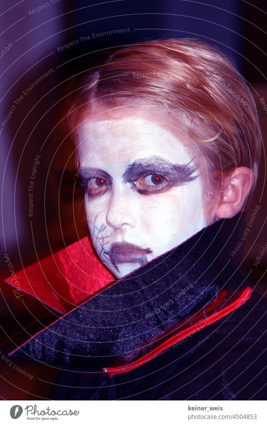 A child made up as a vampire Vampire Child Costume Wearing makeup carnival Carnival Infancy Dracula Hallowe'en Red Eyes Coat Collar Coat collar Face White