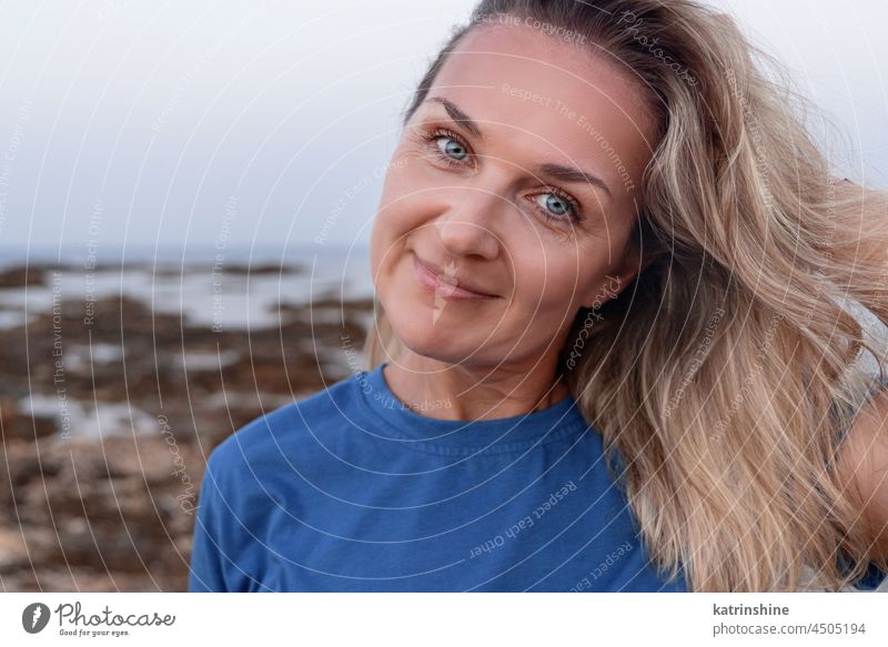Middle aged woman near the sea middle-aged t-shirt outdoor fair haired Blue smile sunset Caucasian adult cheerful happiness Mother lifestyle casual nature