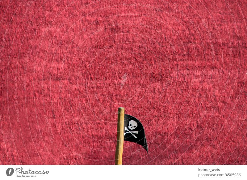 Jolly Roger or the pirate flag in front of red background in somewhere and something with a lot of text free space Jolly Roger. Flag Pirate flag
