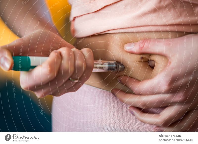 Woman making hormonal therapy injection into her belly. Close up syringe pen. Person in bedroom, in vitro fertilisation treatment. diabetes fertilization