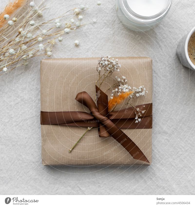 Top view of a gift package with a brown bow and dried flowers Gift Gift wrapping Bow Brown Dried flower Birthday Donate Packaging Package Anticipation Moody