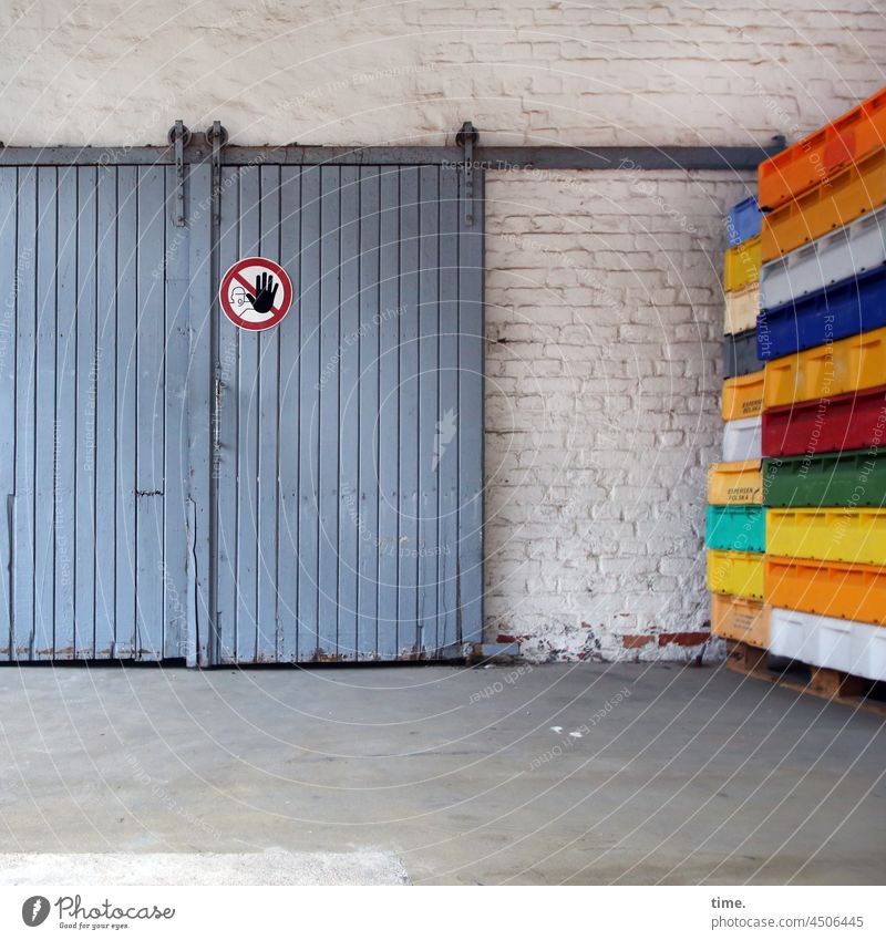 closed today - blue sliding gate with no entry sign next to colourful fish crates on a wooden pallet in front of a whitewashed brick wall Warehouse Goal