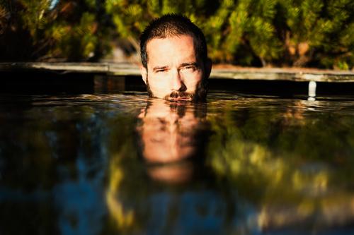 A man, face half under water, bathes outside, surrounded by nature, in the sunshine. Man Face Summer Lake Mirror surround Sun portrait Water Nature Human being