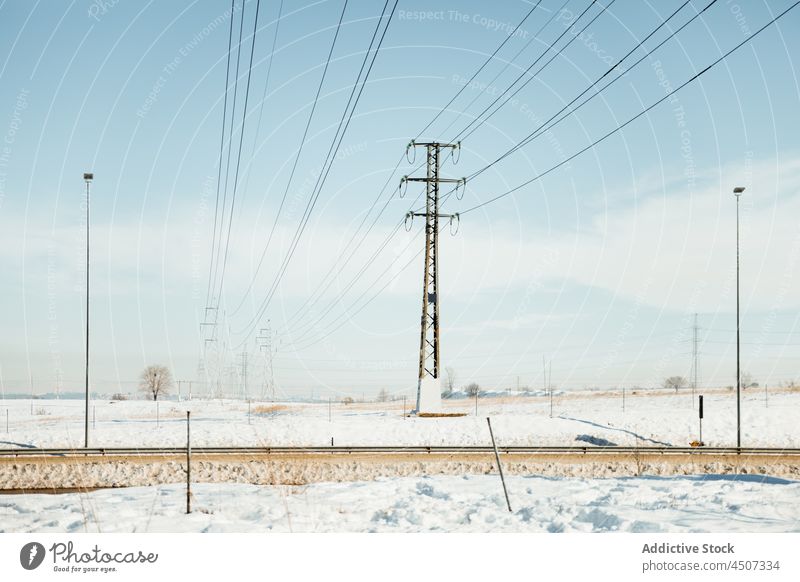Wires between electricity poles in winter landscape nature snow tower power energy wire voltage resource outskirts plant metal vegetate equipment cable