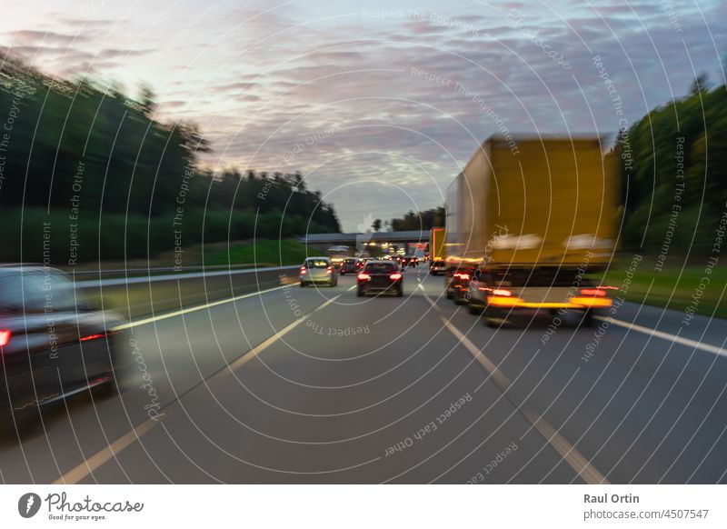 Highway traffic, motion blur vehicles.Transport trucks and cars blurred image. highway road transport speed travel motorway sunset night freeway germany