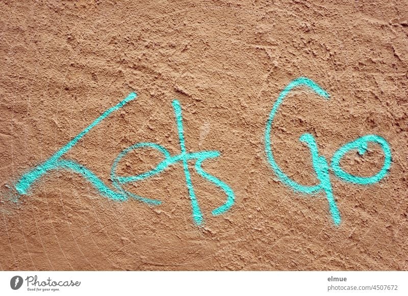 Lets Go is sprayed in turquoise on the plastered wall lets go Graffito English youth welfare Release up and running let go dismissed embassy youth language