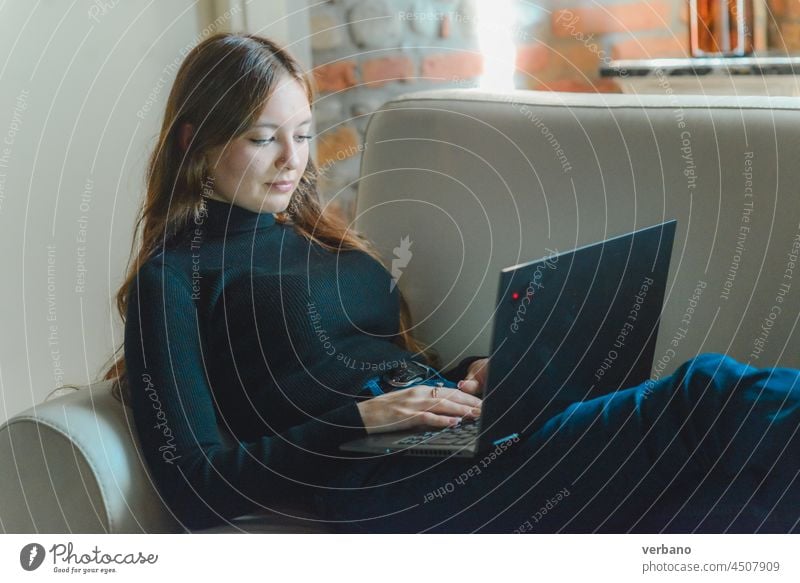 young caucasian woman at the computer remote working on a sofa, cozy at home laptop internet technology lifestyle casual happy beautiful people sitting female