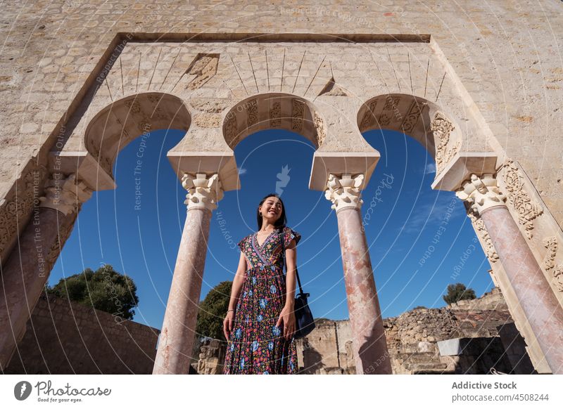 Asian woman standing near historic portico medieval ancient town aged arch old tourist architecture street observe journey admire courtyard arched passage