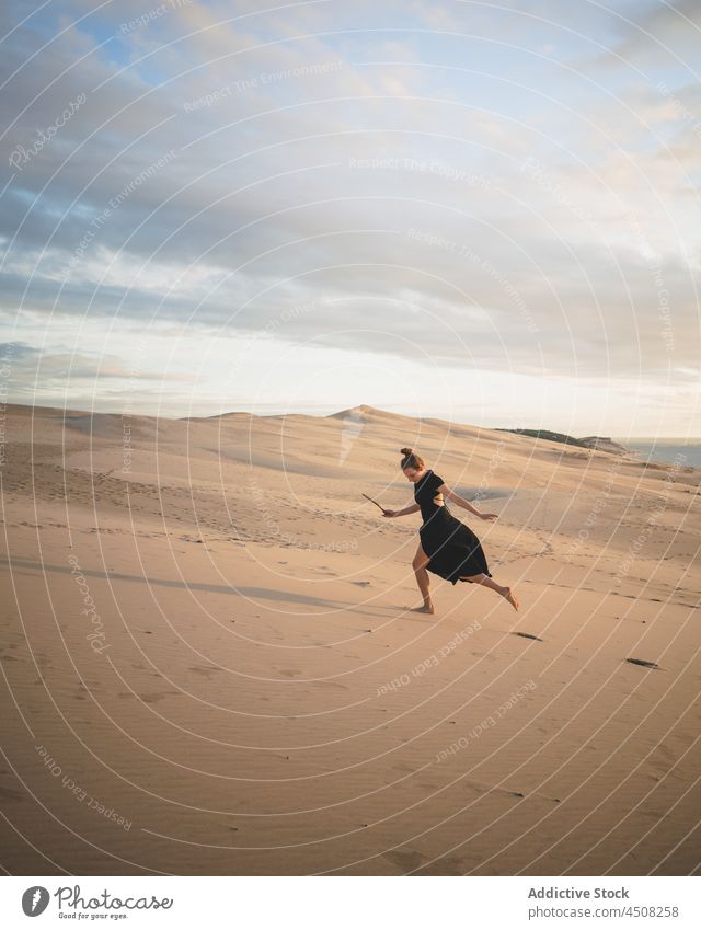 Woman in dress running on sandy dunes woman desert arid hot harmony elegant exotic freedom female serene environment barefoot hill explore heat sunlight drought