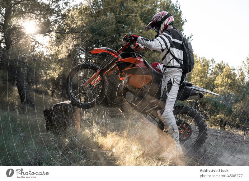Unrecognizable motorcyclist with motorbike on stone man motorcycle extreme vehicle helmet sport nature woodland racer cross country forest male transport
