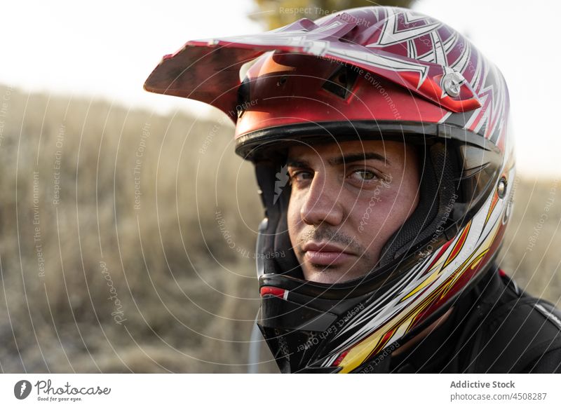 Serious biker in protective helmet man motorbike motorcycle extreme vehicle sport nature field racer male transport motorcyclist activity lifestyle brutal