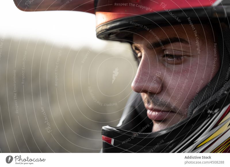 Serious biker in protective helmet man motorbike motorcycle extreme vehicle sport nature field racer male transport motorcyclist activity lifestyle brutal