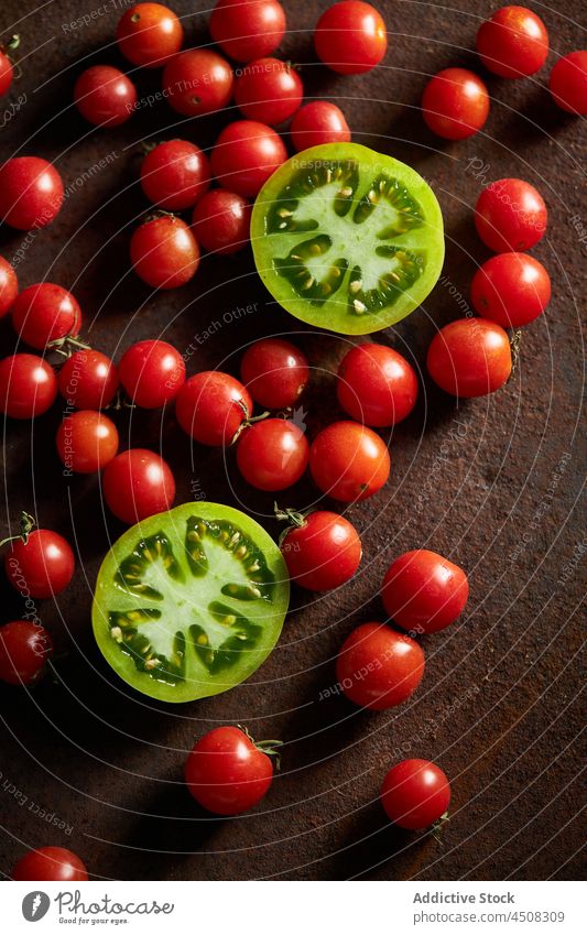 Unripe and red cherry tomatoes on brown surface scatter slice vegetable unripe harvest vitamin many countryside agriculture agronomy garden farm