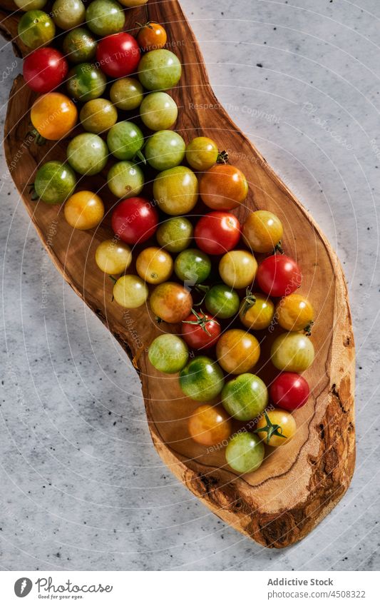 Small wholesome cherry tomatoes on wooden board agriculture harvest unripe vegetable agronomy food many season cultivate healthy countryside rural delicious