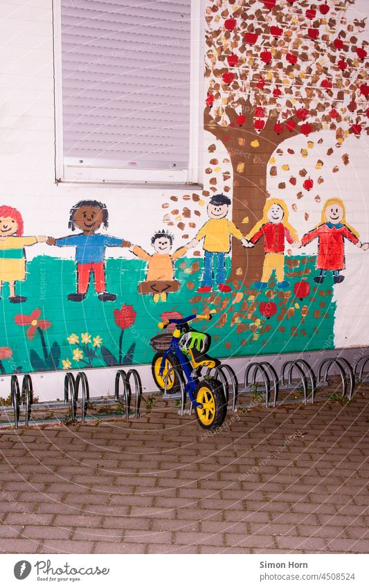 Child bike in front of kindergarten Kindergarten Caregiving Infancy kita Bicycle Parenting Helmet Family Driving Wall (building) impeller Development Loneliness