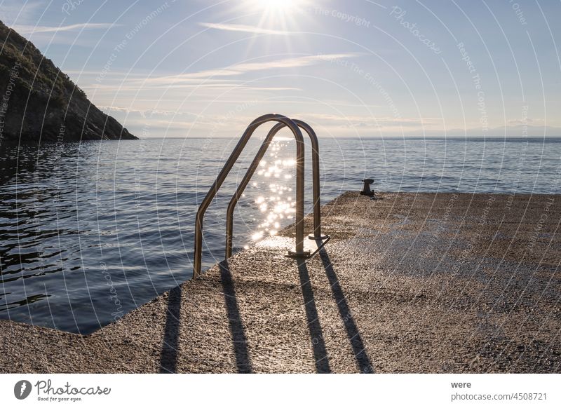 glittering starry sun rays on water behind pool ladder by sea Glittering H2O Ladder Liquid Sea Swimming bathing copy space diving drip drops drowning fluid