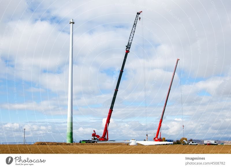 Uninstallation of the old wind turbine. Blades of a wind generator lying on the ground and cranes. Farmland with construction work on the wind farm. Wörrstadt, Germany