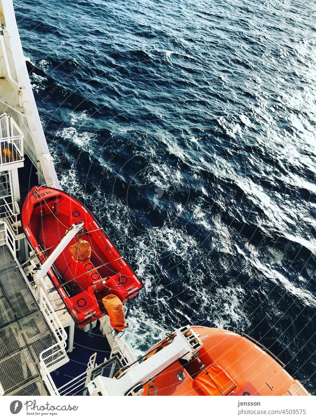 Lifeboats on a ferry across the Baltic Sea Ocean Rescue Safety Water Sea water Navigation ship Red Bright Colours luminescent sunny Sunlight sparkling water