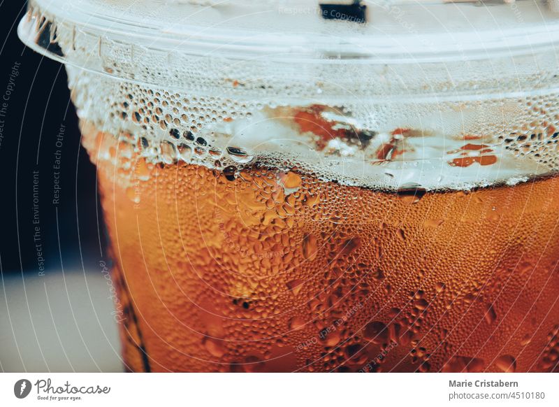 Close up of iced tea with ice cubes inside a plastic cup disposable container cafe no people packaging liquid refreshment disposable cup cool take away