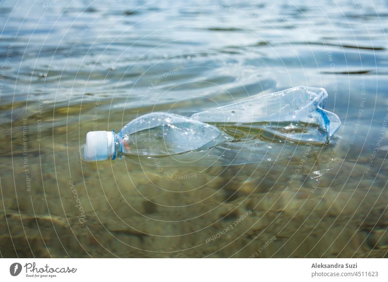 Used plastic bottle floating in clear water. Global environmental problem of plastic pollution on planet. Plastic waste in ocean. background blue climate coast
