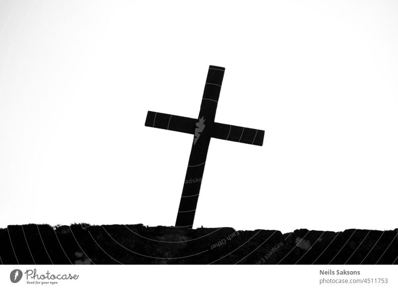 crooked catholic christian cross silhouette on cemetery fence. Black and white abstract art background belief black catholicism christianity church concept