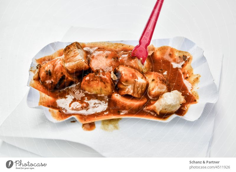 Currywurst in a cardboard bowl with red piecer Hotdog Fast food Eating Food Nutrition salubriously Unhealthy sauce Fork Napkin Delicious Sausage Meat Lunch