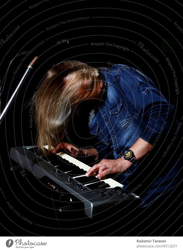 elderly man with long gray hair plays the keys instrument piano music long hair stage musical old musician art person keyboard senior melody male hand sound
