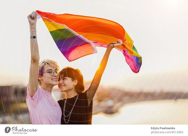 Happy non binary couple waving rainbow flag homosexual couple love together romantic queer non-binary gender fluid lgbt equality millennials gender-blend
